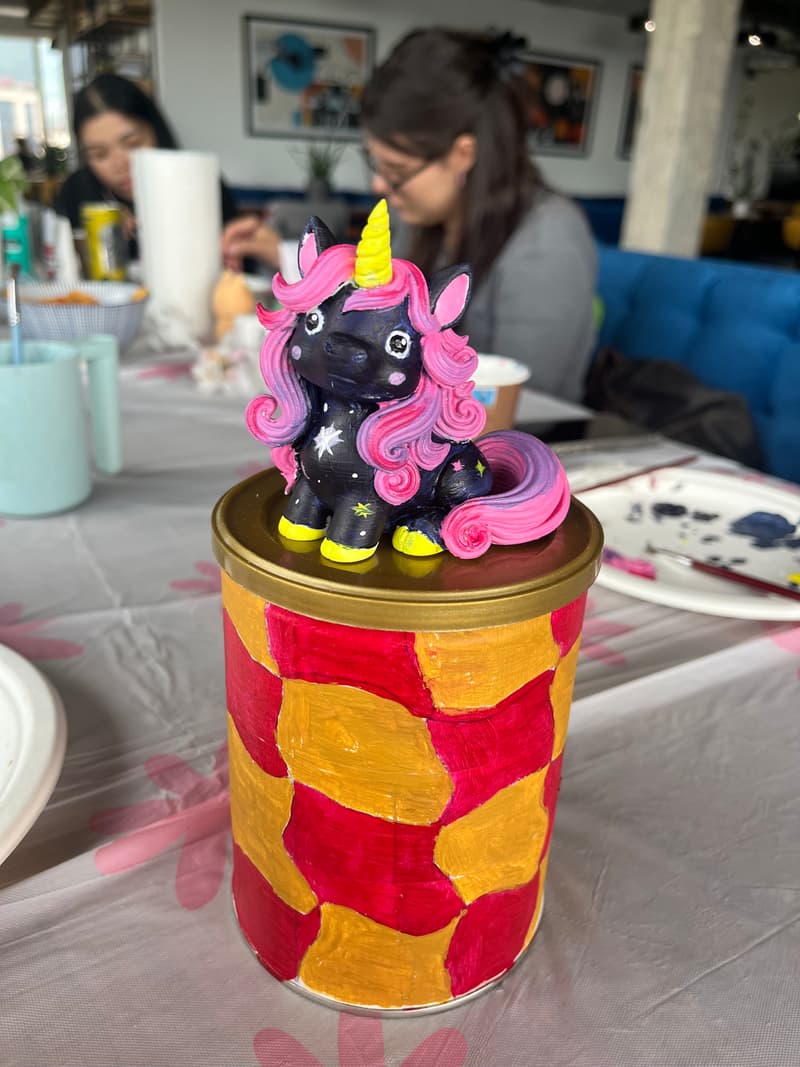 Visitors painting figurines during a partnership event