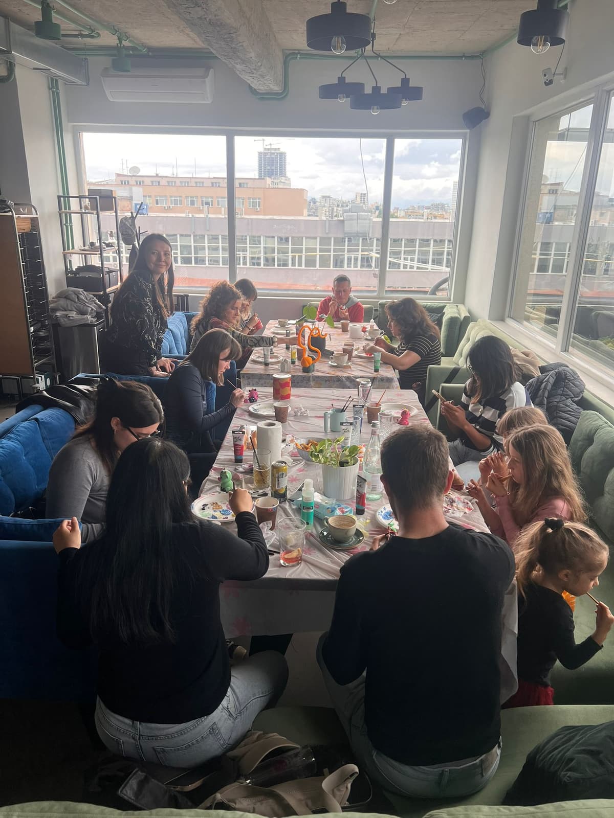 Groupe réuni autour d'une longue table pour peindre des figurines à Strasbourg