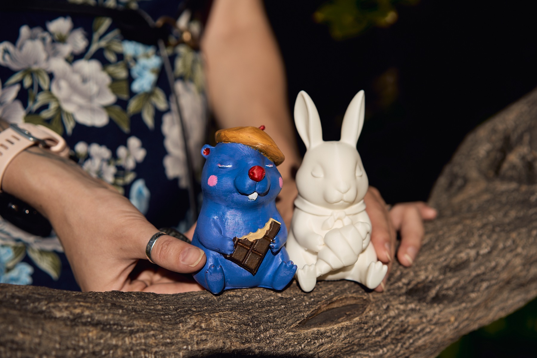 Otto the blue beaver and Colette the white bunny resting together on a tree branch